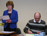 Muriel presenting the Chairman's Address whilst Treasurer John checks his numbers