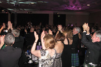 The three hundred plus guests take to the floor to join in a unique rendition of rock band Queen's anthem 'We Will Rock You'