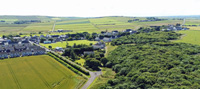 The west end of Castletown. On the right the A836 can be seen stretching all the way to Thurso in the distance.