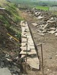 The foundation layer for the retaining wall takes shape