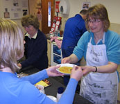 Liz and Muriel serve lunch, whilst John gets stuck into the dishes