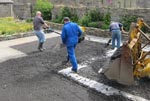 John and Hugh spread the final layer of hardcore on top of the weed control membrane while Neil compacts it down with a vibro-roller